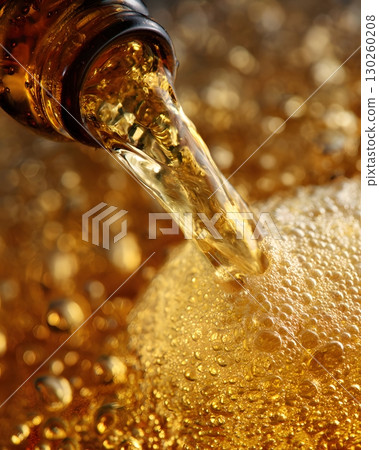 Beer pouring with golden bubbles close-up, 130260208