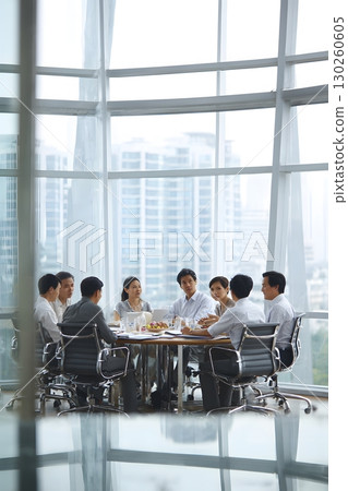 Asian corporate team collaborating in modern conference room 130260605
