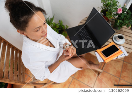 Woman Relaxing with Laptop and Coffee on Outdoor Balcony Workspace 130262099