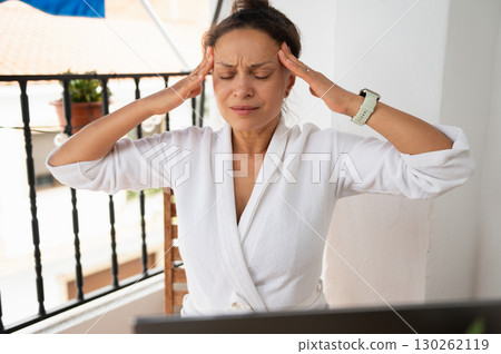 Woman Experiencing Headache While Working at Home in Comfortable Attire 130262119