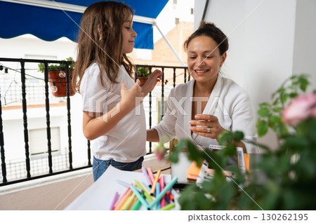Mother and Daughter Bonding Over Arts and Crafts in Open Balcony 130262195