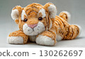 Adorable, Soft Plush Stuffed Tiger Lying Down on the Floor Perfect for Cute Themed Projects, Boosting a Sense of Tranquility and Relaxation. 130262697