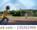 Kids playing baseball at a sunny field during late afternoon with focus on base running and catching 130262966