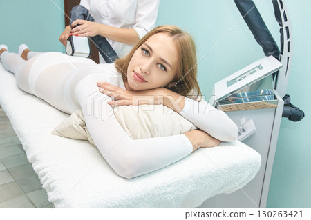 Caucasian young female relaxing during spa treatment session with modern beauty 130263421