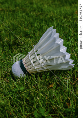 Detailed close-up of a badminton shuttlecock on grass, perfect for sports, recreation, or summer outdoor activity themes. High quality photo 130263757