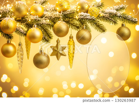 A festive composition with golden Christmas decorations and a garland on a snow-covered branch. 130263987