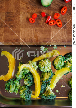 Fresh broccoli and yellow pepper slices on a metal tray, ready for cooking Fresh broccoli and yellow pepper slices on a metal tray, ready for cooking 130264042