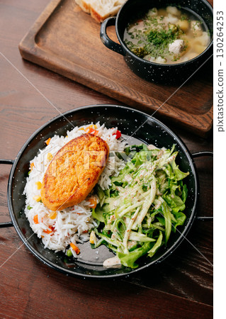 Healthy lunch with vegetable cutlet, rice and green salad on wooden table Healthy lunch with vegetable cutlet, rice and green salad on wooden table 130264253