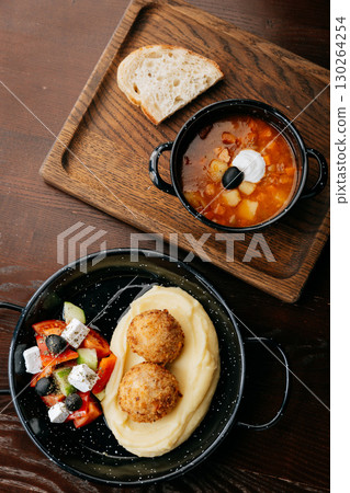 Hearty homemade meal with vegetable soup, mashed potatoes and crispy croquettes Hearty homemade meal with vegetable soup, mashed potatoes and crispy croquettes 130264254