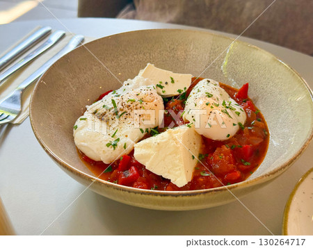 Poached eggs with feta cheese and vegetable stew. Healthy gourmet breakfast. Poached eggs with feta cheese and vegetable stew. Healthy gourmet breakfast. 130264717