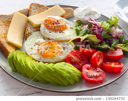 Healthy breakfast with eggs, avocado, toast, cheese, salad and matcha latte. Nutritious start of the day, wellness and modern cafe food. 130264732
