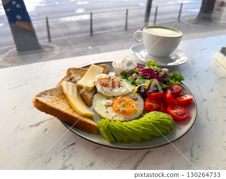 Healthy breakfast with eggs, avocado, toast, cheese, salad and matcha latte. Nutritious start of the day, wellness and modern cafe food. Healthy breakfast with eggs, avocado, toast, cheese, salad and matcha latte. Nutritious start of the day, wellness and modern cafe food. 130264733