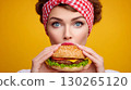 The girl suffers from an addiction to unhealthy fast food and looks at the burger with appetite 130265120