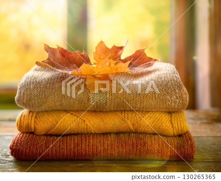 Stacked wool autumn sweaters on wooden background 130265365