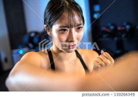 一個很酷的女人在健身房做拳擊練習,用右拳出拳 一個很酷的女人在健身房做拳擊練習,用右拳出拳 130266349