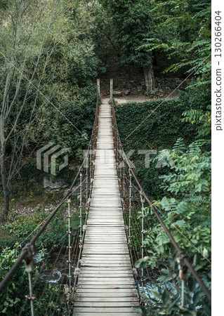 Old Suspension Bridge in the Forest. Adventure and Nature Concept Old Suspension Bridge in the Forest. Adventure and Nature Concept 130266404