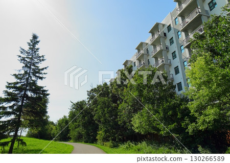 Modern apartment building with green trees and walkway Modern apartment building with green trees and walkway 130266589