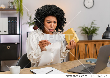 African American businesswoman reads letter frowns sad at tough email job rejection or lost chance African American businesswoman reads letter frowns sad at tough email job rejection or lost chance 130267124