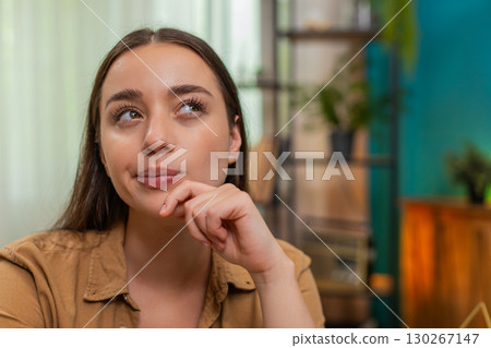 Young woman close up resting chin on hand thinking hard about solution looking for creative answer Young woman close up resting chin on hand thinking hard about solution looking for creative answer 130267147