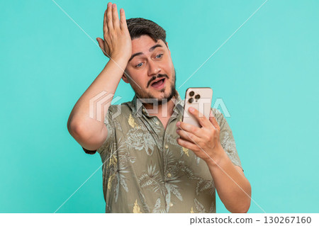 Man scrolling smartphone suddenly hitting forehead with palm remembering important task or deadline 130267160