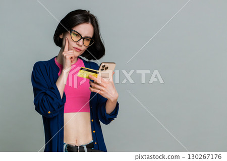 Woman smiling holding credit card pointing to camera clearly indicating shopping payment gesture Woman smiling holding credit card pointing to camera clearly indicating shopping payment gesture 130267176