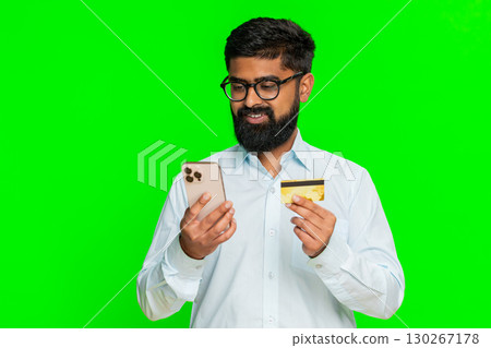 Indian man holding smartphone and credit card entering numbers online shopping payment chroma key 130267178