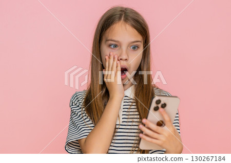 Child girl kid reading unexpected surprising message on smartphone eyes wide open shocked reaction 130267184