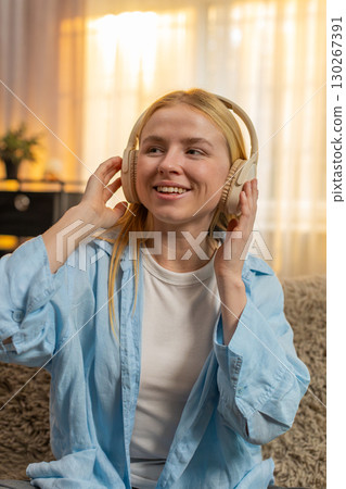 Young woman enjoying calm tunes at home, closed eyes, gentle sway, peaceful vibe, sofa relaxation Young woman enjoying calm tunes at home, closed eyes, gentle sway, peaceful vibe, sofa relaxation 130267391