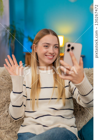 Caucasian woman smiling laughing talking during phone video call on sofa at home joyful emotions 130267472