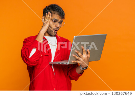 Displeased Indian man use laptop surprised by bad news, fortune loss, game fail, lottery results 130267649