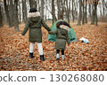 Beautiful little black girls standing near tent in the forest. Two little sisters playing in autumn forest. Black girls wearing khaki coats. 130268080