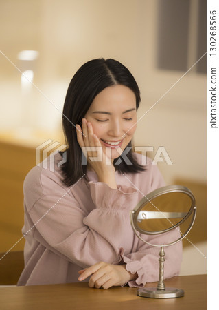 A woman doing skin care at night in her bedroom 130268566
