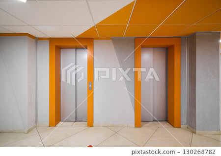 A Modern Elevator Lobby that Features Stylish Orange Accents Enhancing Its Overall Aesthetic A Modern Elevator Lobby that Features Stylish Orange Accents Enhancing Its Overall Aesthetic 130268782