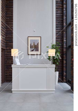 This modern reception area has a minimalist design with warm, inviting lighting This modern reception area has a minimalist design with warm, inviting lighting 130268796
