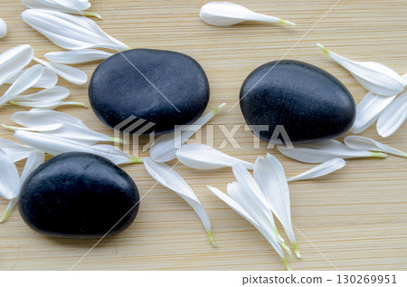Paired stones resting on large green leaf over neutral wooden surface with customizable space for text. Paired stones resting on large green leaf over neutral wooden surface with customizable space for text. 130269951