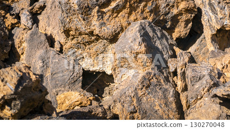 Lava formations, stones, black basalt in the rocks closeup on a volcano terrain. Lava formations, stones, black basalt in the rocks closeup on a volcano terrain. 130270048