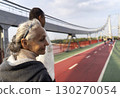 Smiley old woman and her husband walks on the footbridge. 130270054