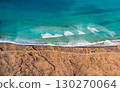 Blue ocean with waves and a sandy beach, top view. 130270064