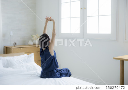 A woman sitting on a bed 130270472