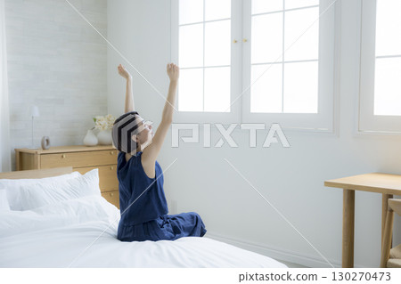 一個女人坐在床上 130270473