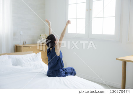 A woman sitting on a bed 130270474