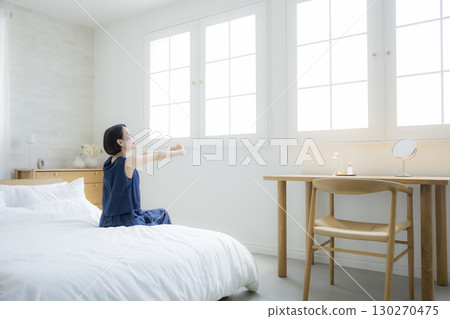 A woman sitting on a bed 130270475