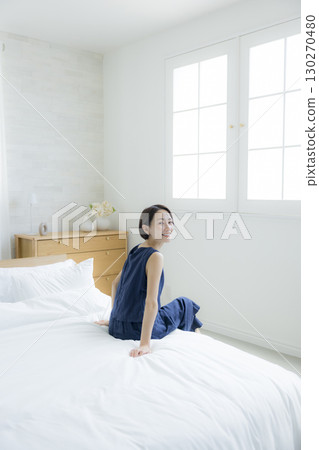 A woman sitting on a bed 130270480