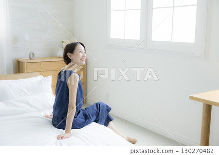 一個女人坐在床上 一個女人坐在床上 130270482