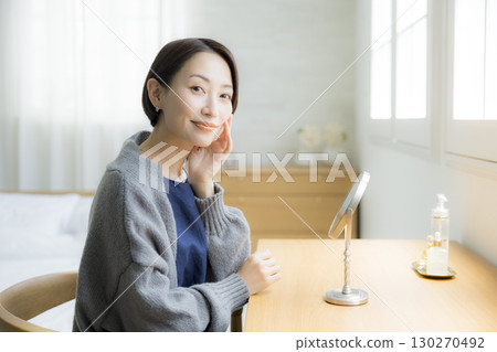 A woman in a knitted outfit doing skin care 130270492