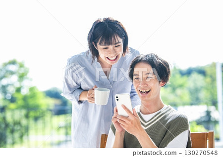 A couple searching on a smartphone A couple searching on a smartphone 130270548