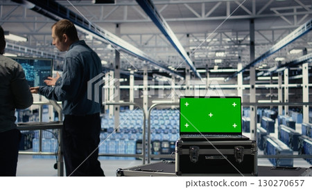 Data center programmers deploying deep learning software on rigs using green screen laptop. Server hub coworkers train AI systems with datasets using mockup notebook to support applications, camera A 130270657