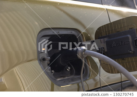 Close up shot of EV automobile electrical motor preparing to be resupplied with electricity. Electric car charging port cover opened to recharge depleted battery, green energy concept 130270745