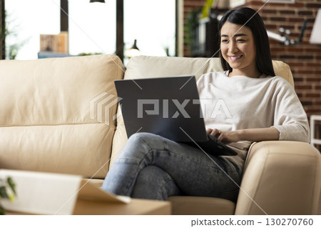 Female freelancer researching strategies and reviewing emails while managing tasks remotely. Asian entrepreneur excited after completing financial data and project presentation from home. Female freelancer researching strategies and reviewing emails while managing tasks remotely. Asian entrepreneur excited after completing financial data and project presentation from home. 130270760