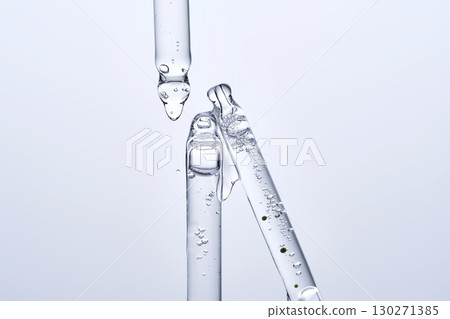 Three different face serum pipettes on a neutral background. 130271385